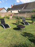 two chairs and a table in a yard at Lou Bohème in Le Briou