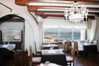 ein Restaurant mit Tischen und Stühlen mit Blick auf das Meer in der Unterkunft Hotel Restaurante Risco in Laredo