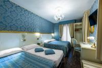 a hotel room with two beds and blue walls at Hotel Il Mercante di Venezia in Venice
