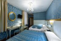 two beds in a room with blue wallpaper at Hotel Il Mercante di Venezia in Venice