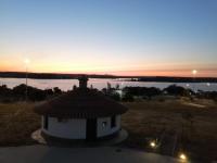 een uitzicht op een gebouw met een zonsondergang op de achtergrond bij Cruceros Alqueva in Cheles