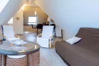 Habitación con cama, mesa y sillas. en Appartement 100m2 Vilvic vue mer, en Trégunc