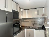 a kitchen with white cabinets and a stove top oven at TAN&#39;MAYEVA APPART * in Mamoudzou