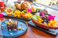 Una mesa de madera con platos de comida encima. en Awe Villa Boutique Trancoso, en Trancoso