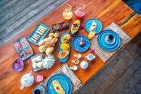 Una mesa de madera cubierta con platos de comida y bebidas. en Awe Villa Boutique Trancoso, en Trancoso