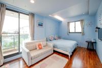 a bedroom with blue walls and a bed and a couch at Yilan My House Homestay B&amp;B in Dayin