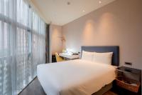 a bedroom with a bed and a desk and a window at CHECK inn Taipei Xinyi in Taipei