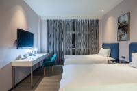 a hotel room with two beds and a desk at CHECK inn Taipei Xinyi in Taipei