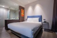 a bedroom with a large bed and a bathroom at CHECK inn Taipei Xinyi in Taipei