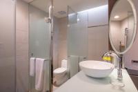 a bathroom with a sink and a toilet and a mirror at CHECK inn Taipei Xinyi in Taipei