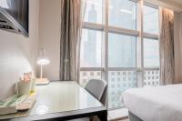 a hotel room with a desk and a bed and a window at CHECK inn Taipei Xinyi in Taipei