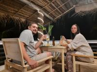 un homme et une femme assis à une table avec des boissons dans l'établissement Villa Freiheit Himmel, à Bentota