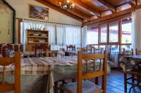 a dining room with a table and chairs and windows at Hotel Uña Serranía Encantada in Uña
