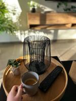 a person holding a cup of coffee and a remote control at Maison piscine &amp; spa Vallon Pont d&#39;Arc in Vallon-Pont-dʼArc