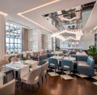 a restaurant with tables and chairs and a chandelier at Kaya Palazzo Resort & Casino in Kérynia