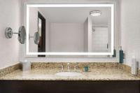 a bathroom with a sink and a large mirror at DoubleTree by Hilton Chicago O'Hare Airport-Rosemont in Rosemont