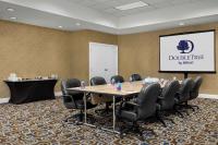 a conference room with a table and chairs and a screen at DoubleTree by Hilton Chicago O'Hare Airport-Rosemont in Rosemont