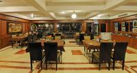 Un gran comedor con mesas y sillas. en Hotel Mahabs, en Mahabalipuram