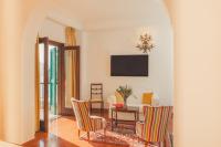 a living room with a table and chairs and a television at Hotel Poseidon in Positano