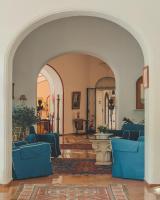 a living room with blue chairs and an archway at Hotel Poseidon in Positano