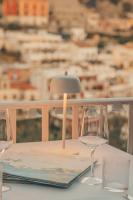a table with two wine glasses and a lamp on it at Hotel Poseidon in Positano