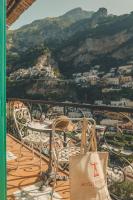 a table and chairs on a balcony with a view of a city at Hotel Poseidon in Positano