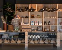 un uomo è in piedi dietro uno scaffale in un negozio di AutoCamp Asheville ad Asheville