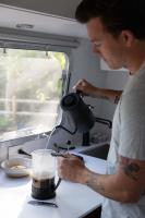 un uomo sta versando una bevanda in una tazza di AutoCamp Asheville ad Asheville