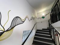 a staircase in a house with a mural on the wall at Contact Hôtel Foch in Besançon