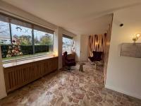 a living room with a large window and a chair at Contact Hôtel Foch in Besançon