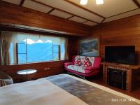a bedroom with a bed and a tv and a chair at Shiyai Taoyuan in Ren&#39;ai