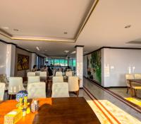 een restaurant met witte stoelen, een tafel en een scherm bij Vang Vieng Consiana Hotel in Vang Vieng