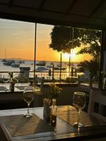 a table with two glasses on a table with a view of the ocean at Pousada Corsario Buzios in Búzios