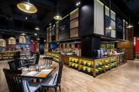 Un restaurante con mesas y sillas y un bar. en Pullman Ciawi Vimala Hills Resort, en Bogor