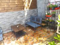 a patio with a bench and a table and some plants at Ti kaz Payet,la fraicheur des hauts in Le Tampon