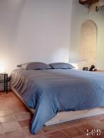 a bed in a bedroom with a blue comforter at Le Buffon in Dijon