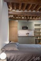 a bedroom with a large bed and a kitchen at Le Buffon in Dijon
