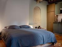 a bedroom with a bed with a blue comforter at Le Buffon in Dijon