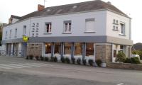 a white building on the corner of a street at Hotel au Moyne De Saire in Réville