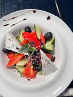 a white plate with a salad of fruit and vegetables at Design Hotel Skopeli in Odesa