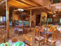 Un comedor con mesas y sillas de madera. en Mindo Garden Lodge and Wildlife Reserve, en Mindo