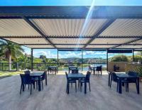 een terras met tafels en stoelen en uitzicht op het water bij Pousada Villa Shalom in Igaratá