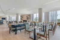 Un restaurante con mesas y sillas y una chimenea. en Cambria Hotel Austin Downtown, en Austin