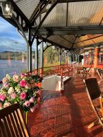 Una terraza cubierta con flores, mesas y bancos. en Hotel Refugio Santa Ines, en Aquitania