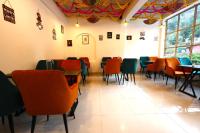 un comedor con sillas y mesas coloridas en Chopta House Hotel and Restaurant, en Sari