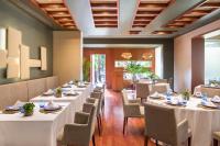 uma sala de jantar com mesas e cadeiras brancas em Barceló Murcia Siete Coronas em Múrcia