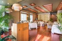 uma sala de jantar com mesas e cadeiras brancas em Barceló Murcia Siete Coronas em Múrcia