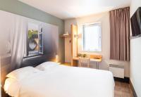 リモージュにあるB&amp;B HOTEL Limoges 1の白いベッドと窓のあるホテルの部屋