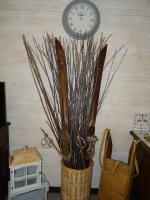 a vase with branches in it next to a clock at Le Clos Fleuri in Caumont