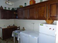 a kitchen with a white refrigerator and wooden cabinets at Le Clos Fleuri in Caumont